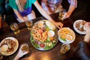 friends eating and drinking at bar or pub