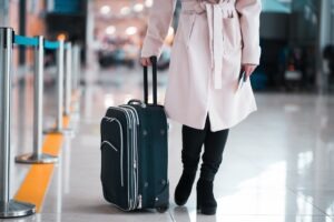 Legs of businesswoman with baggage in airport.