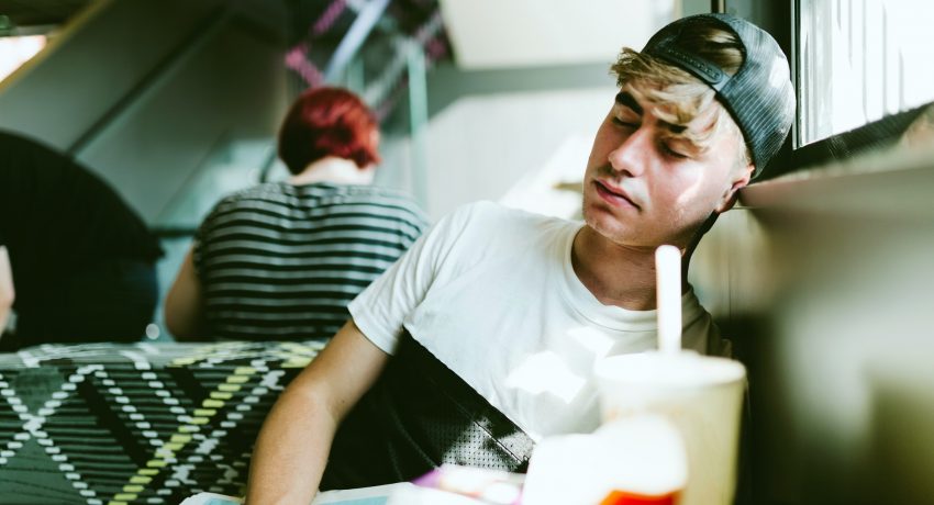 Handsome young man sleeping in the airport.