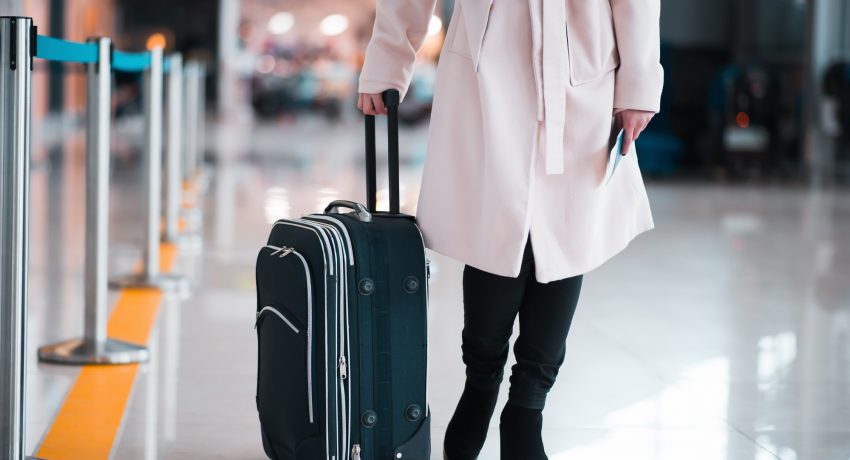 Legs of businesswoman with baggage in airport.